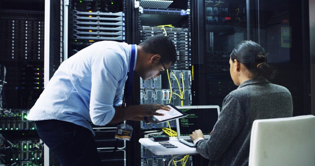 a man and woman working to fix a problem in a server room